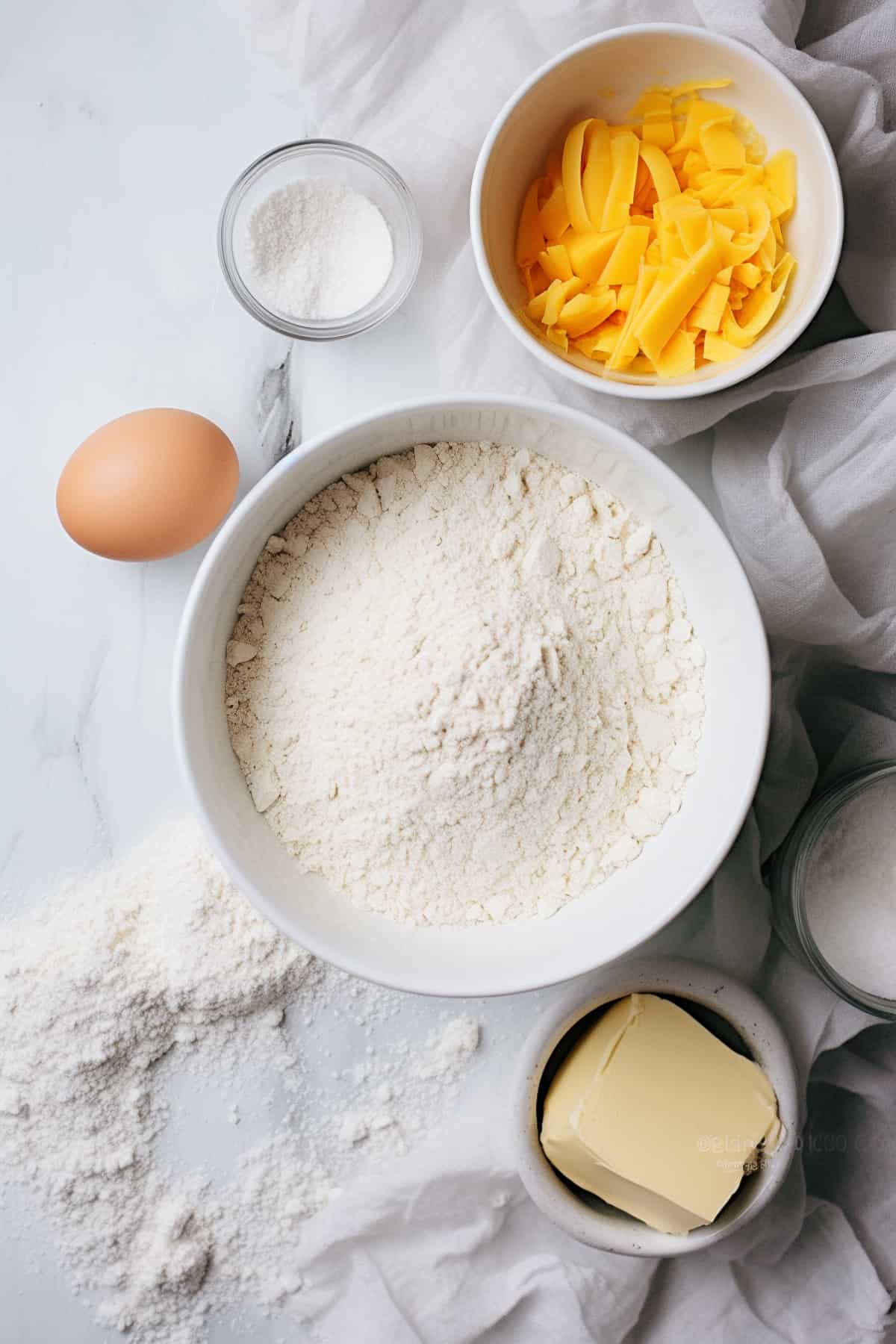 Ingredients for cheese scones on a marble table.