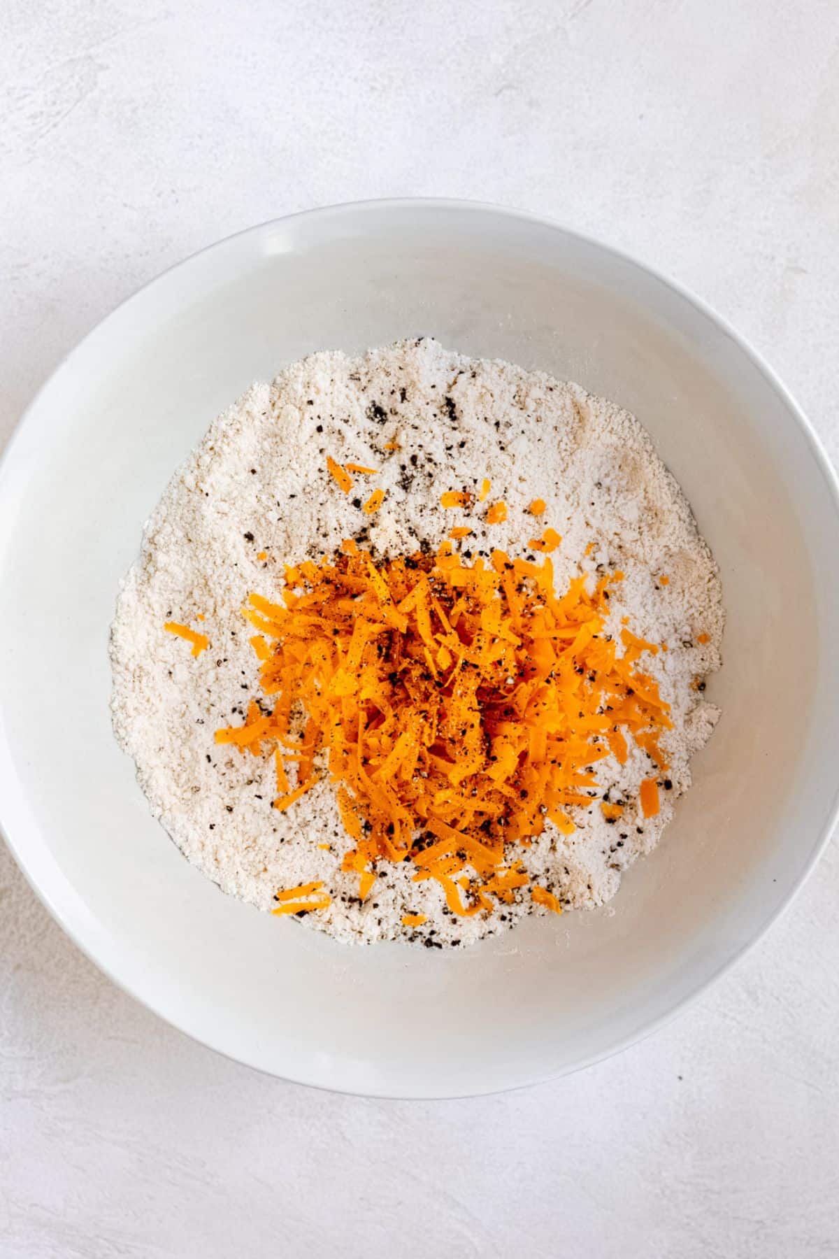 Cheese being mixed into butter and flour mixture.