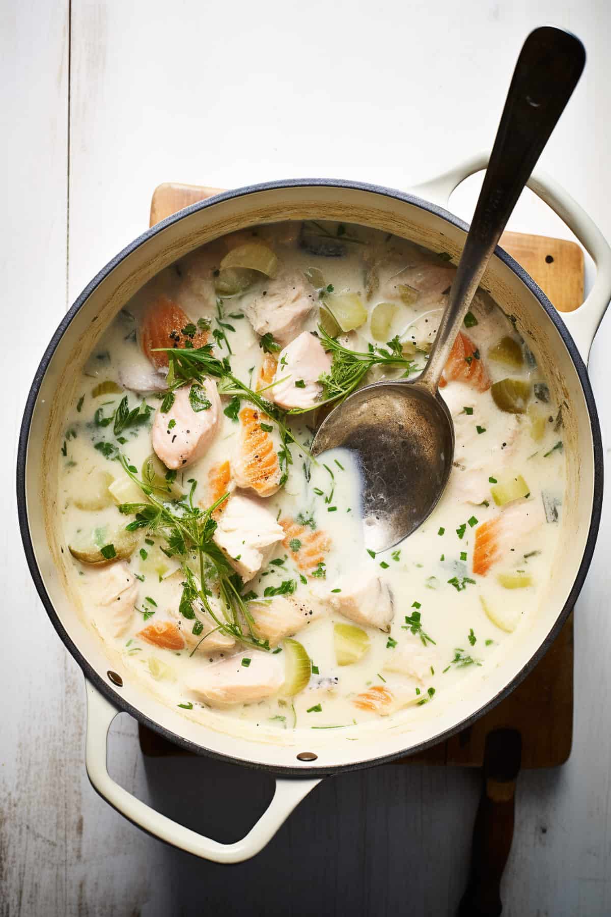 Fish pie filling in a pot, including salmon, white fish and herbs.