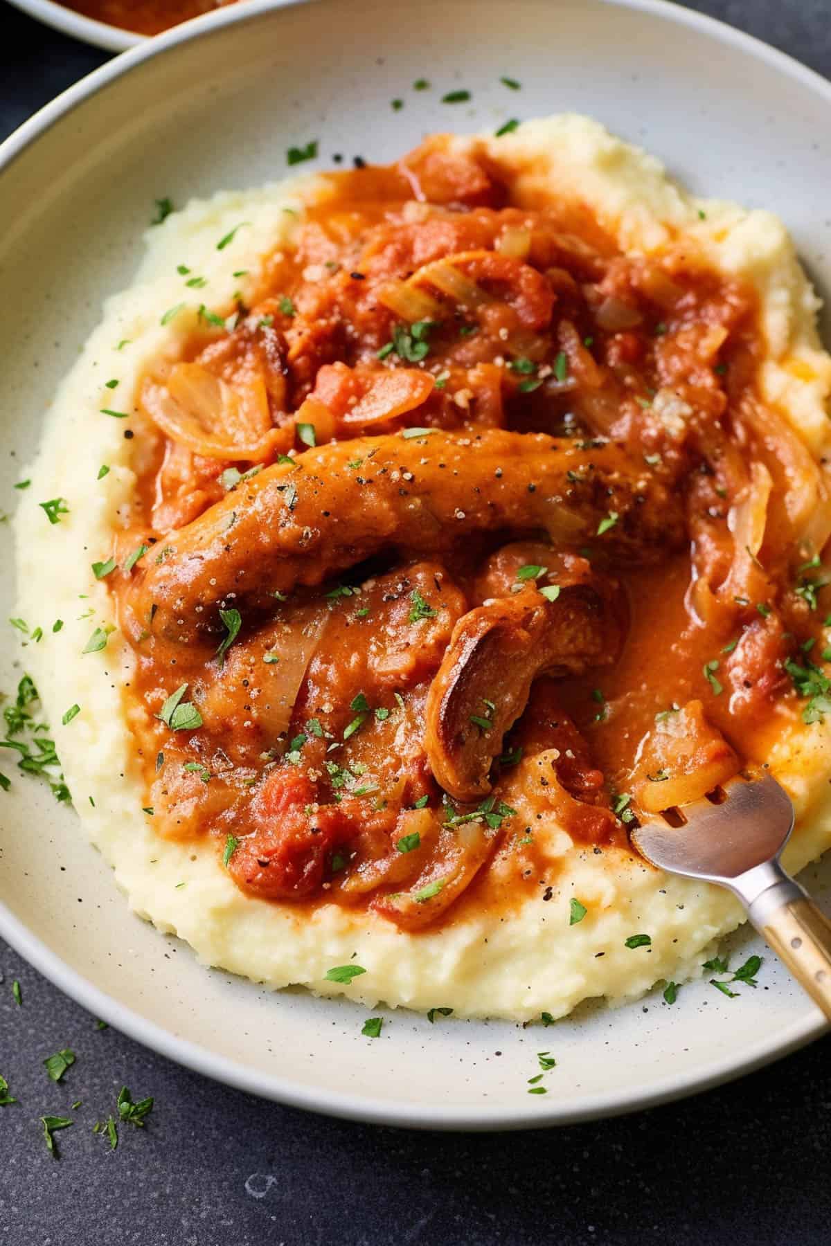 Slow cooker sausage casserole over mashed potatoes.