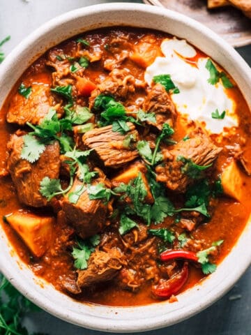 Slow cooker lamb curry in a white bowl.