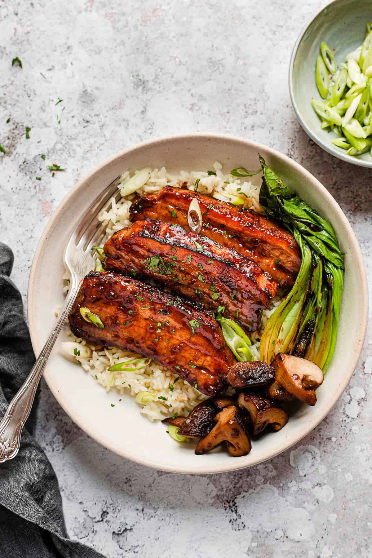 Roasted pork belly slices with honey garlic glaze on white rice.