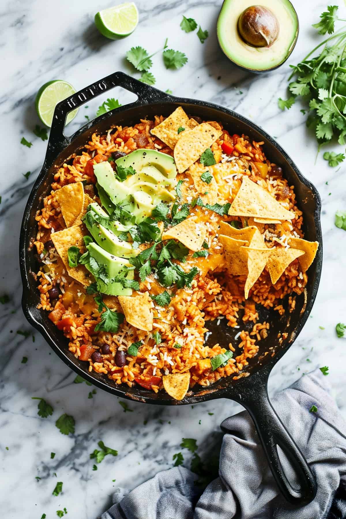 One pot Mexican rice in a skillet with avocado and tortilla chips.