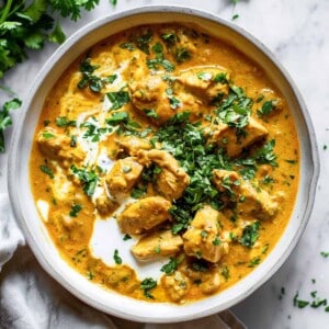 Creamy slow cooker chicken Korma with chopped coriander served with rice.
