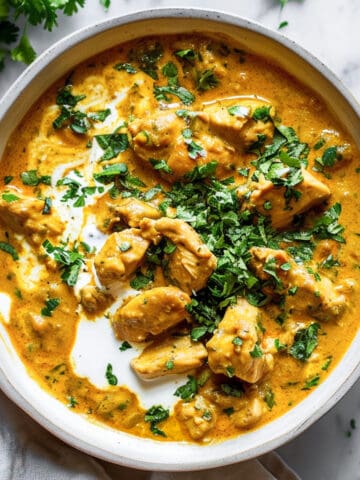Creamy slow cooker chicken Korma with chopped coriander served with rice.