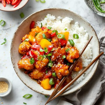Easy sweet and sour chicken with peppers and pineapple on a white plate.