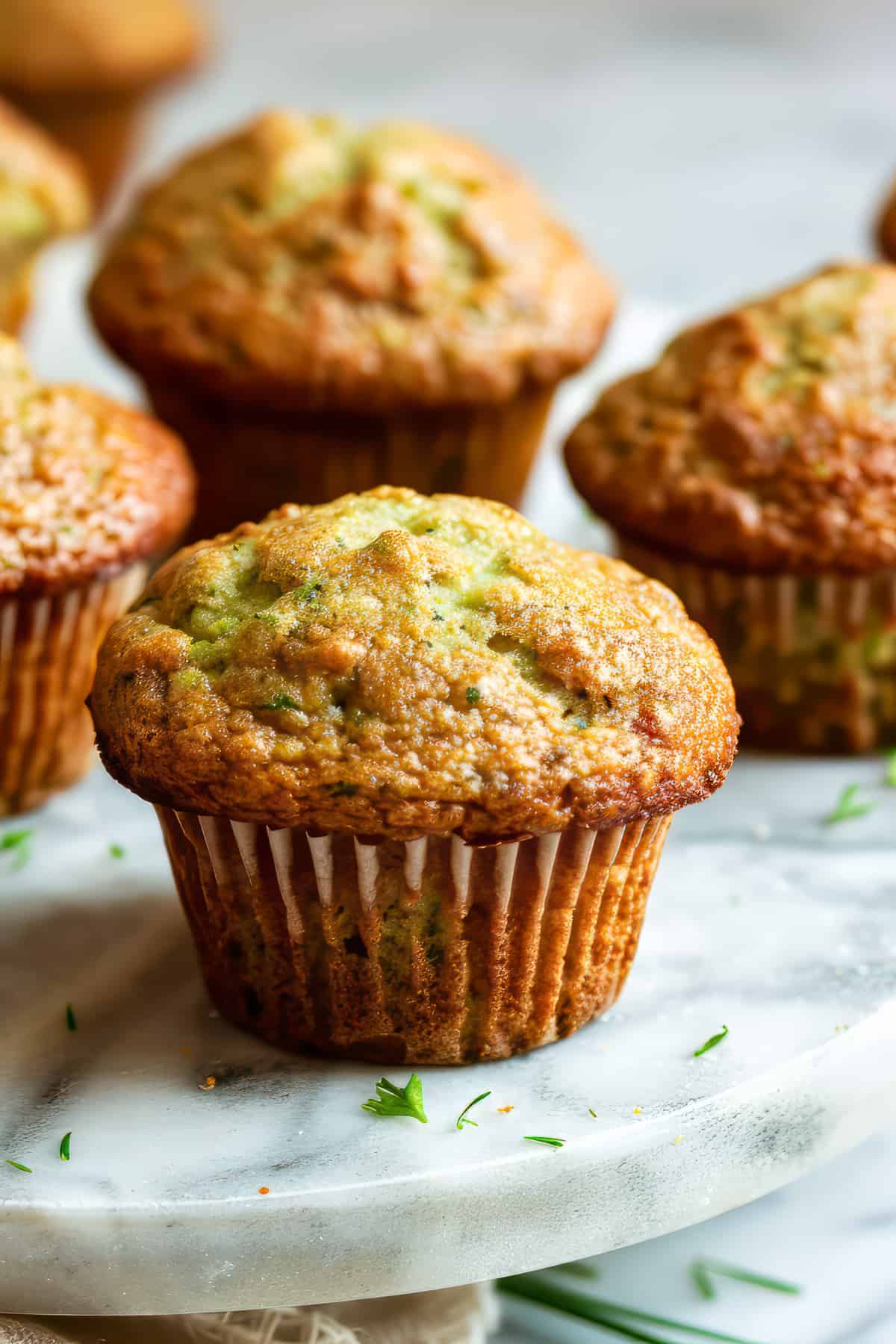 Courgette muffins on a white table.