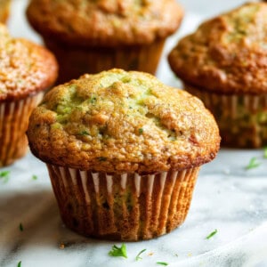 Courgette muffins on a white table.