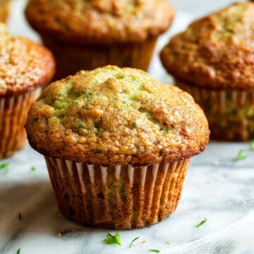 Courgette muffins on a white table.