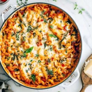 Vegetable pasta bake with penne in a casserole dish with baked cheese.