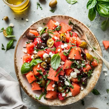 Greek watermelon and feta salad in a bowl with olives and basil.