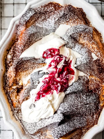 French toast bake with cream and raspberry preserves in a baking dish.