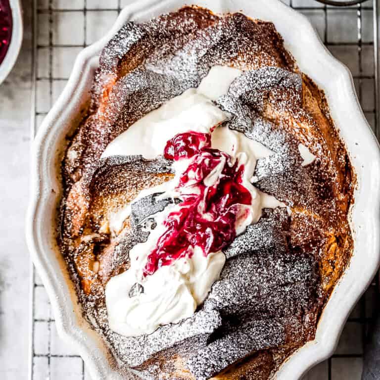 French toast bake with cream and raspberry preserves in a baking dish.