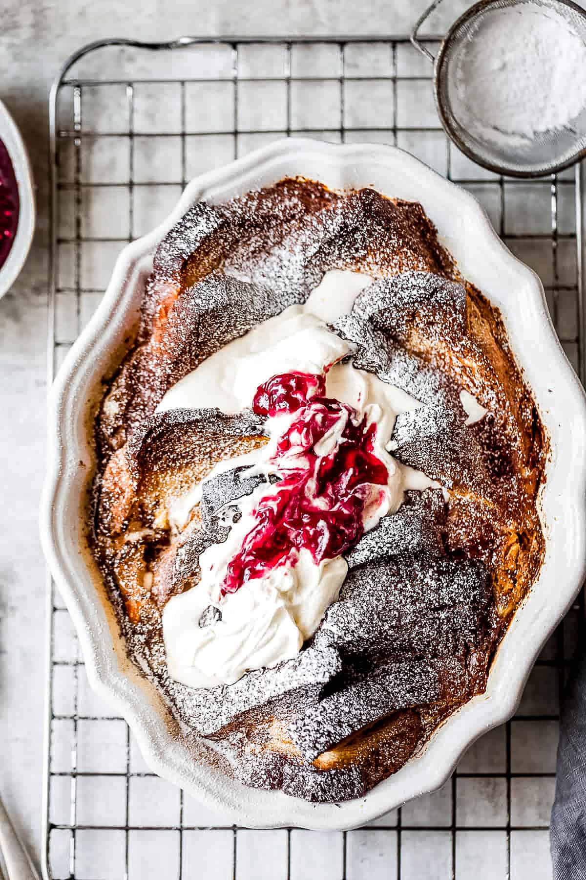 French toast bake with cream and raspberry preserves in a baking dish.