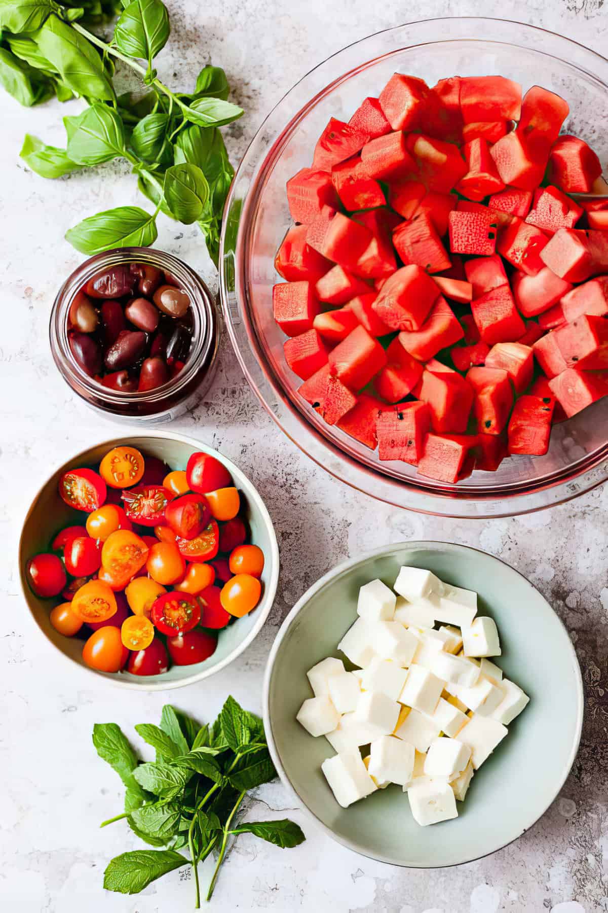 Chopped ingredients in bowls for watermelon and feta salad.