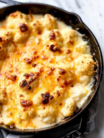 Baked cauliflower cheese in a skillet.