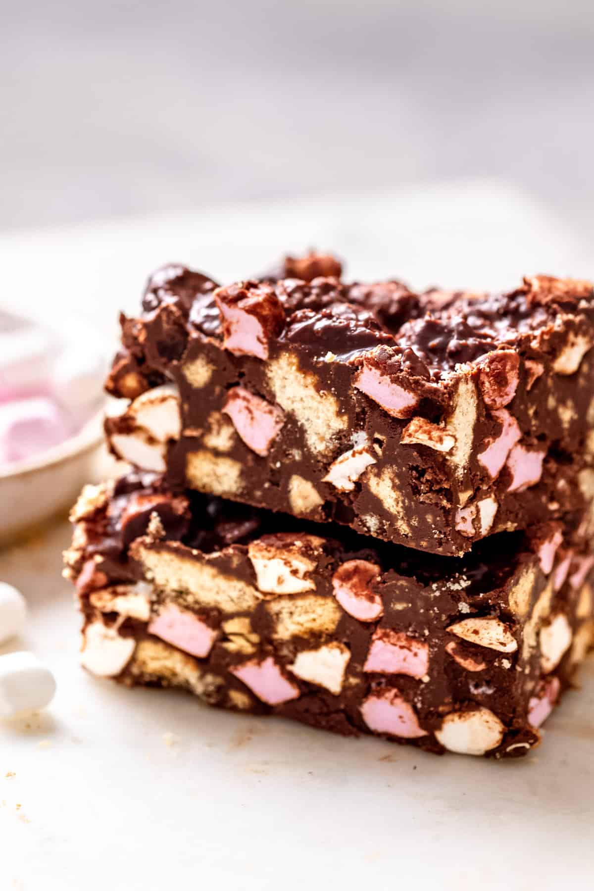 Rocky road bars on a white marble table with marshmallows.