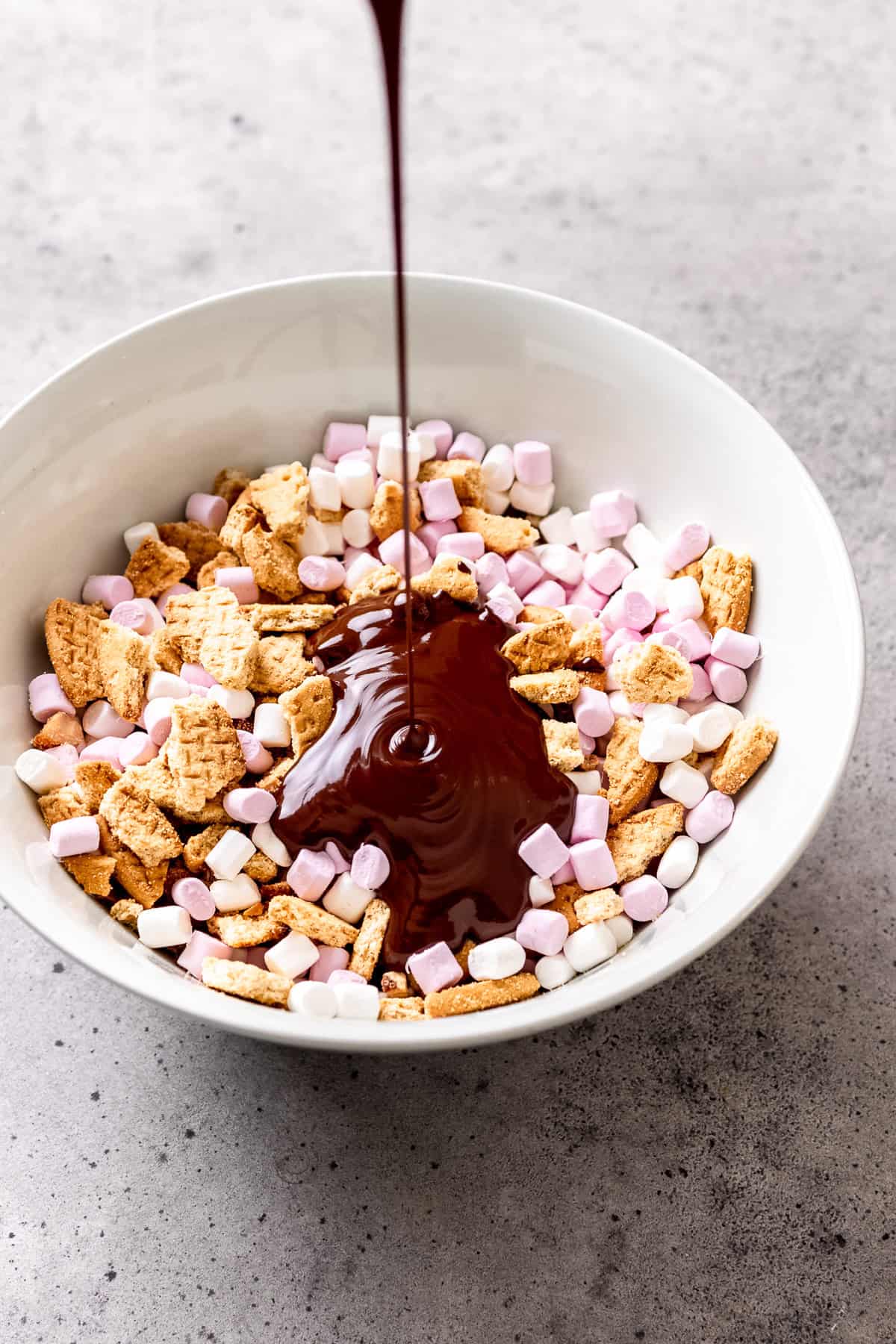 Chocolate being poured into marshmallows and biscuits for rocky road.