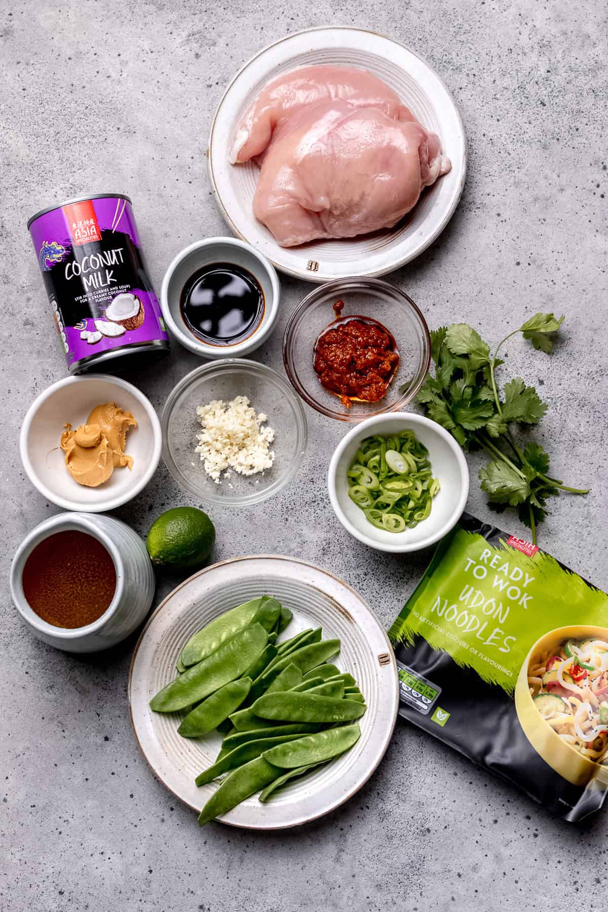 Ingredients for spicy peanut ramen on a white table.