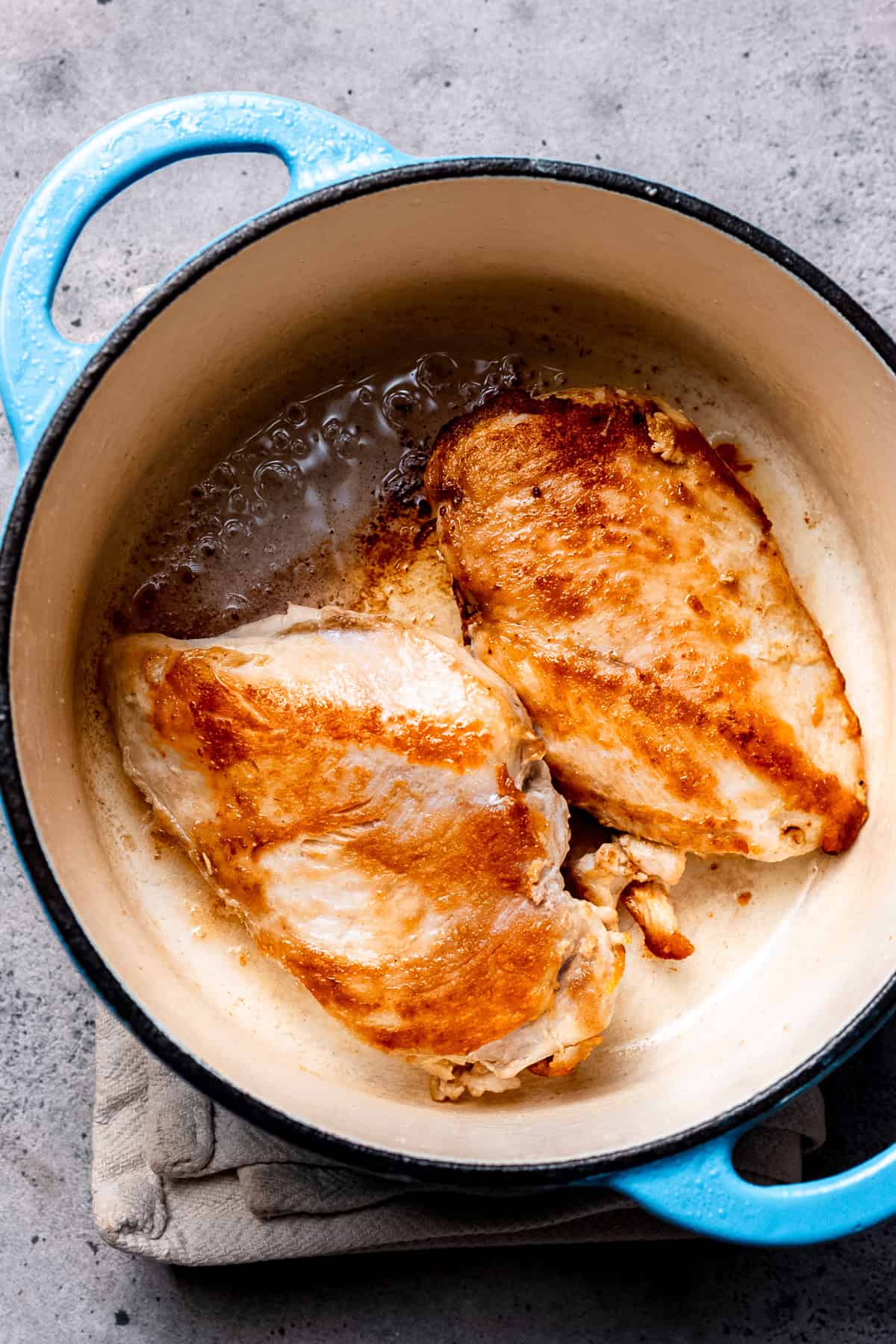 Chicken being seared for ramen noodle soup.