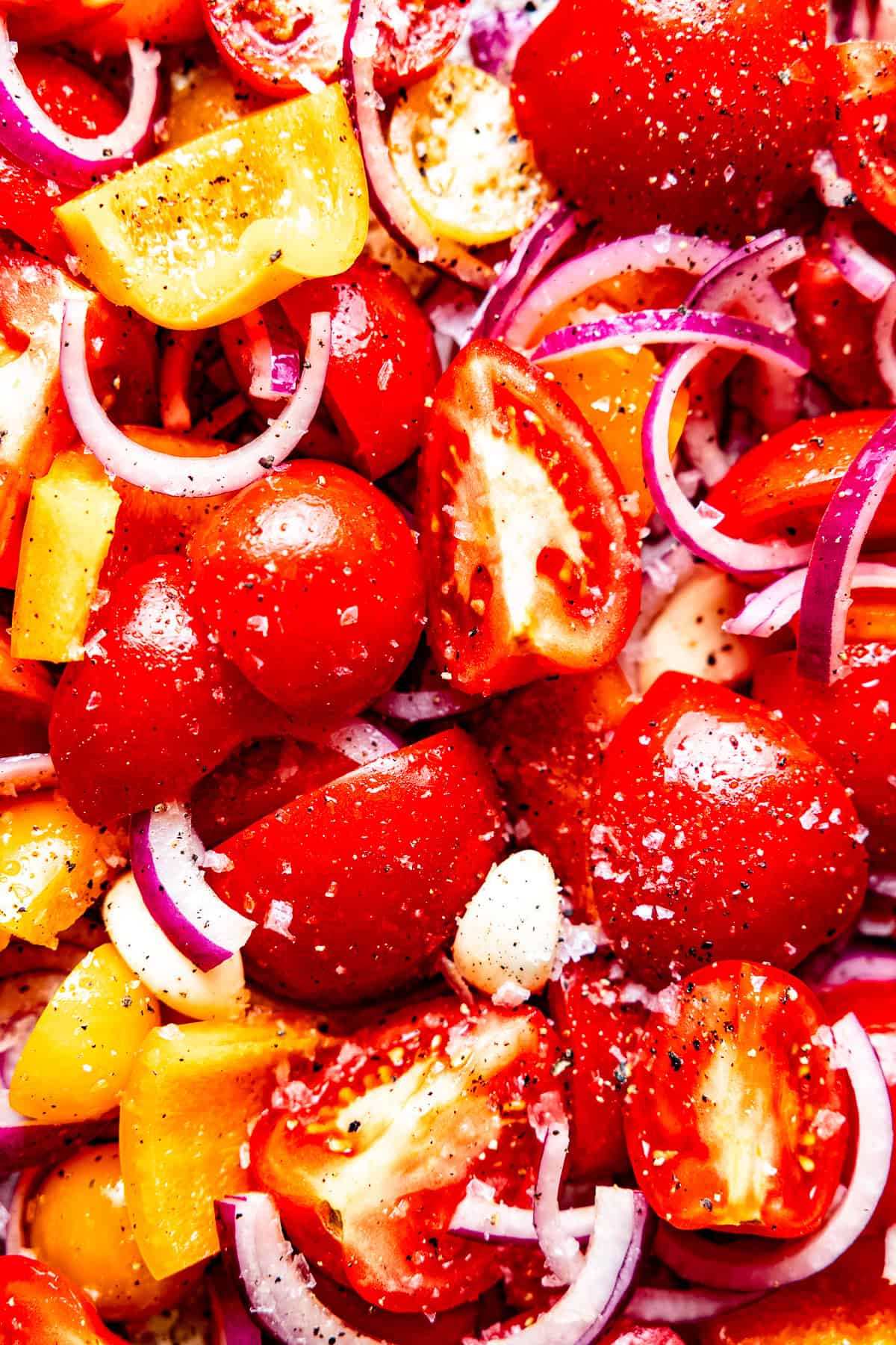 Fresh tomatoes in with garlic in a roasting pan for soup.
