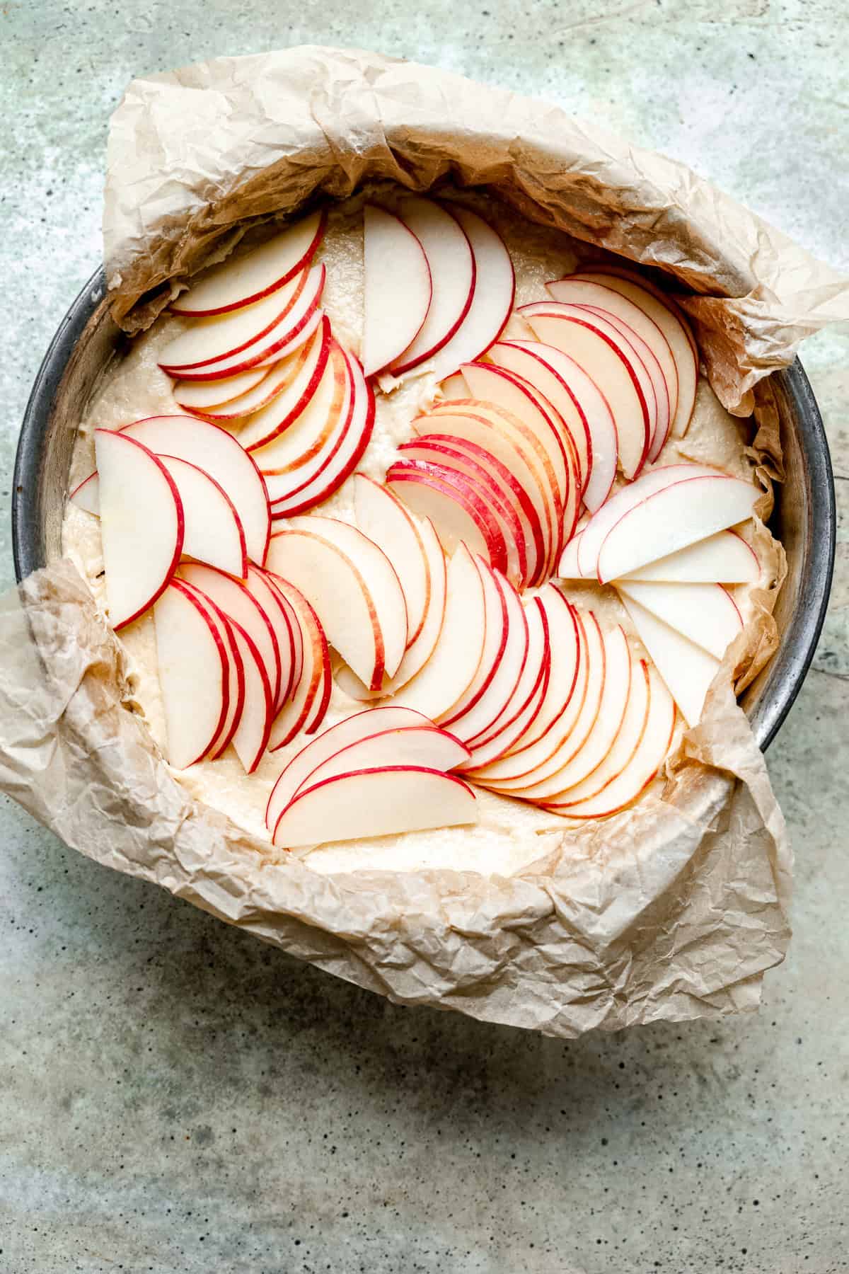 Apple slices layered on top of the cake before being baked.