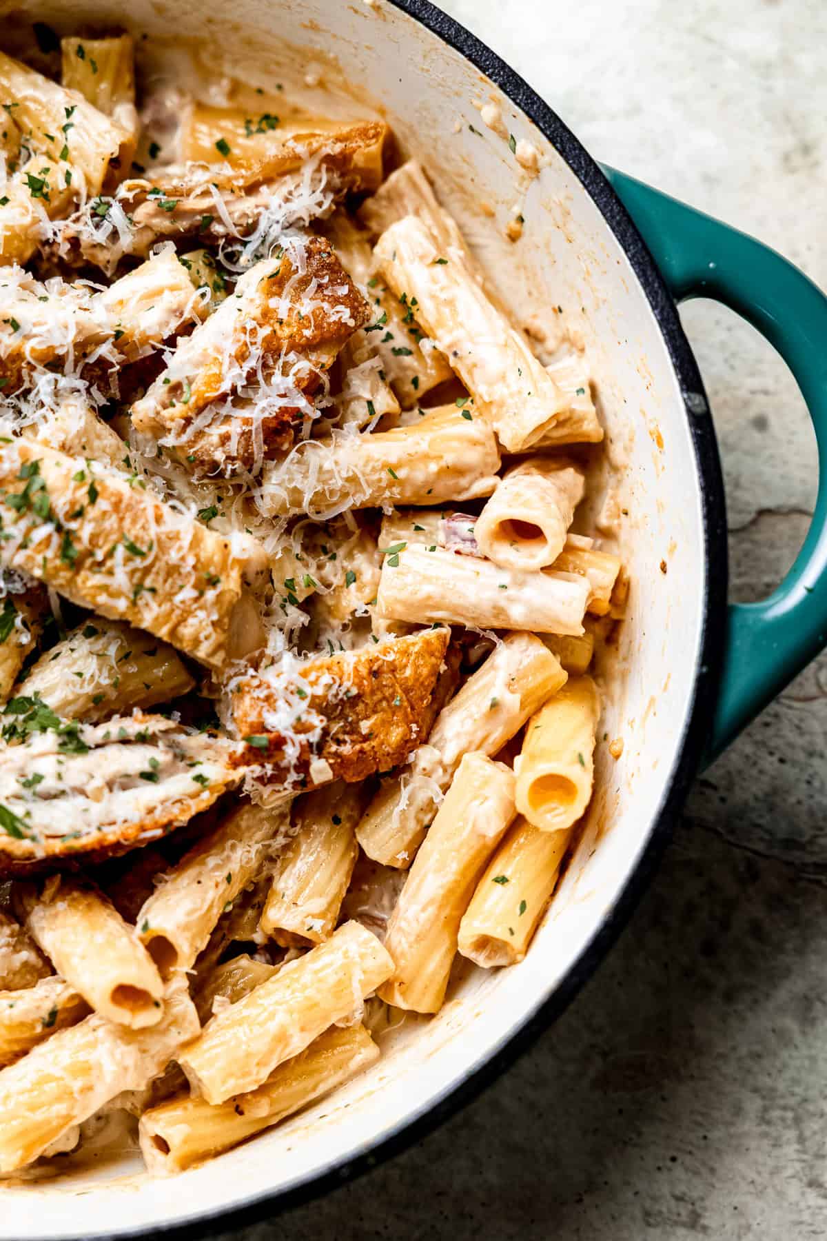 Close up of creamy chicken and bacon pasta in a skillet.
