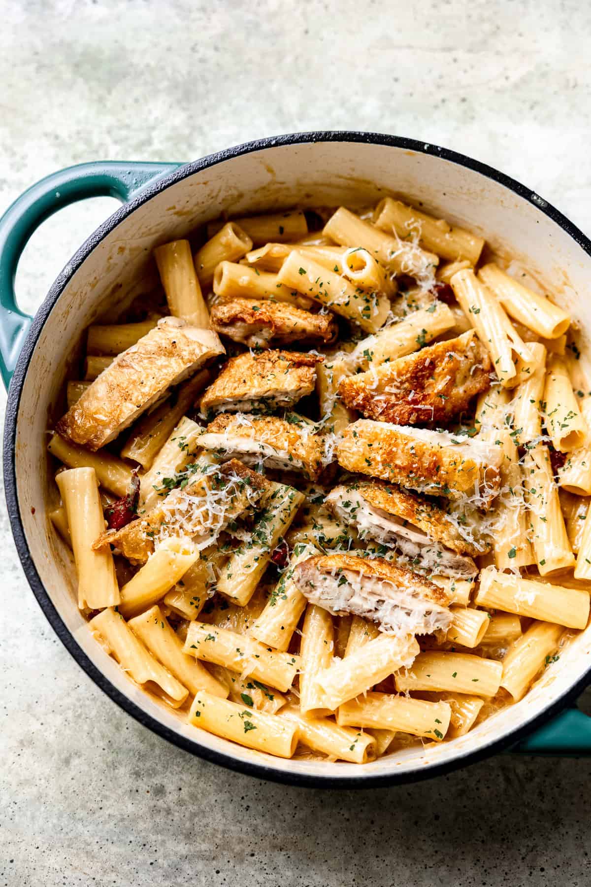 Chicken and bacon pasta in a pan with parsley and cream sauce.